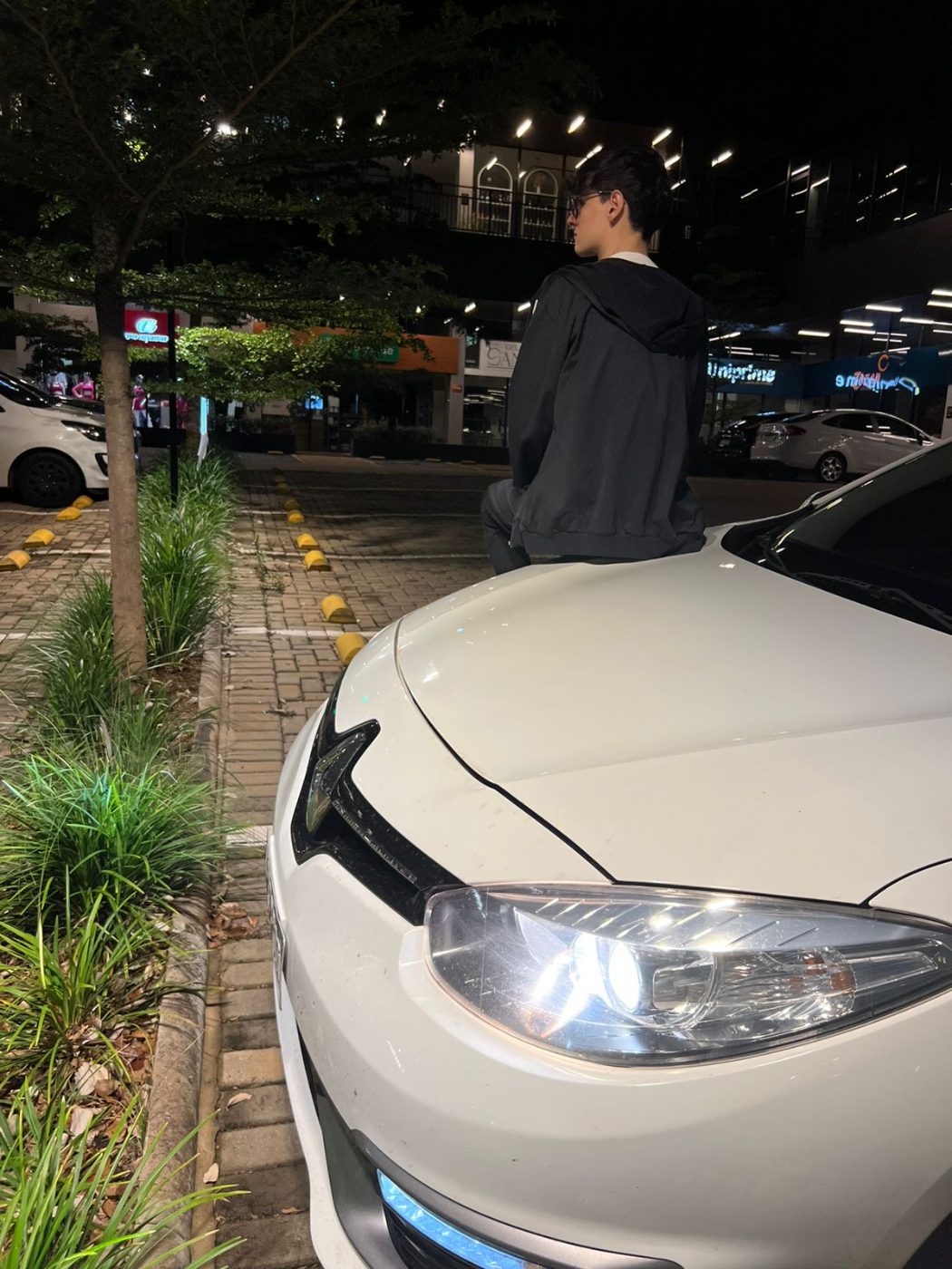 Luiz sentado no capô do Fluence